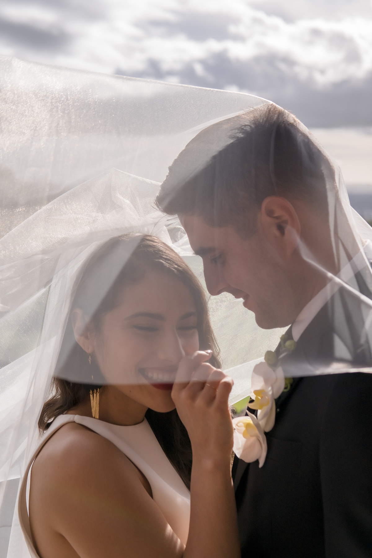Wedding Couple Laughing as They Take Pictures Under the Veil